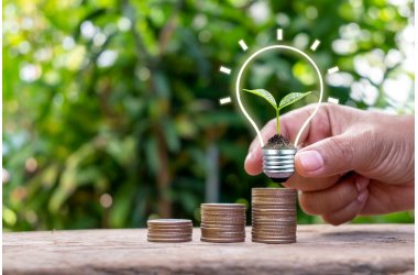 Energiesparlampe mit Münzstapel